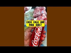 a hand holding a can of coca - cola and pork ribs