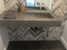 a bathroom sink sitting under a mirror next to a wall mounted soap dispenser