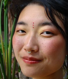 a woman with piercings on her nose looking at the camera