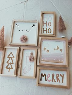 four wooden frames with christmas pictures hanging on the wall next to some pine cones and pom - poms