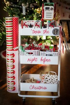 a christmas gift wrapping station in front of a christmas tree