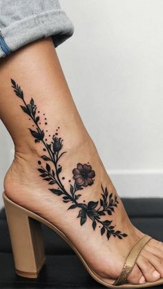 a woman's foot with a flower tattoo on the side of her leg and ankle