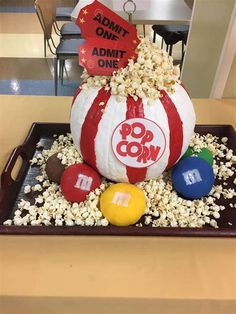 a tray with popcorn and balls on it in the shape of a pumpkin that says pop corn