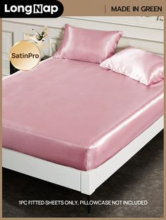 a bed with pink sheets and pillows on it