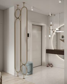 a white and gold bathroom with an oval mirror on the wall next to a blue stool