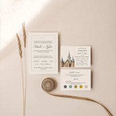 the wedding stationery is laid out on top of the table, along with some dried grass