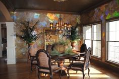 a dinning room table with chairs and potted plants on the top of it