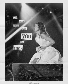 a woman sitting on top of a piano in front of a stage with words written on it