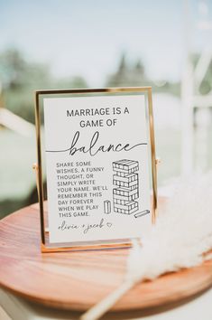 a sign that is sitting on top of a wooden table next to a white feather