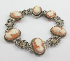 Beautiful hand carved shell cameo bracelet depicting the 'clasic' profile of a woman with open floral motifs in between. The frames are simple with a rope pattern. Very elegant and stylish. Some patina on it. Marked 800 Camexco & C (or something similar) Measurements: approx. 7 inches long and approx. 0.7 inches across Please note that due to lighting effects, monitor's brightness, contrast and other settings, there might be some slight differences in the color tone/shade of the web site's photo Elegant Adjustable Cameo Bracelets, Elegant Carved Adjustable Bracelet, Collectible Vintage Bracelets, Vintage Collectible Bracelets, Elegant Carved Bracelet, Elegant Adjustable Carved Bracelet, Elegant Silver Bracelet With Cameo, Engraved Oval Bracelets, Vintage Adjustable Cameo Bracelet