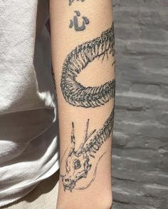 a person with a tattoo on their arm has a dragon and fish design on it