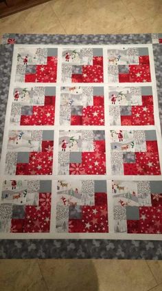 a red and gray quilted table topper on a tile floor with christmas decorations