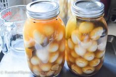 two jars filled with food sitting on top of a table