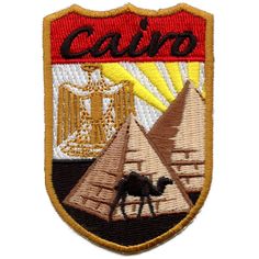 an embroidered patch with the words, cajo and two pyramids in front of it