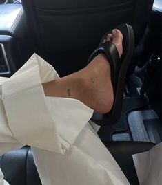 a woman's feet in a car with her dress on