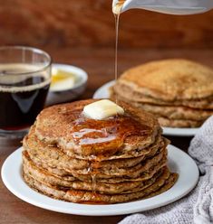 a stack of pancakes with syrup being drizzled on top