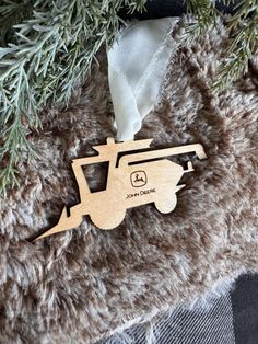 a wooden ornament hanging from the side of a christmas tree with a white ribbon