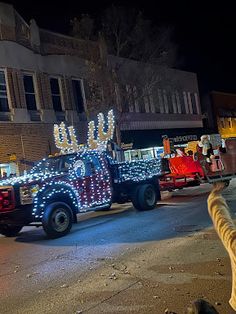 a truck decorated with christmas lights driving down the street