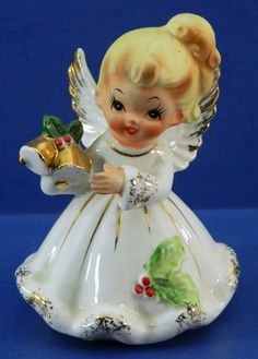 a little angel figurine holding a bell