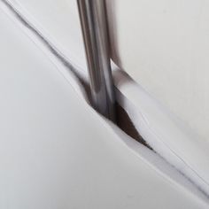 a metal pole sticking out of the side of a white wall