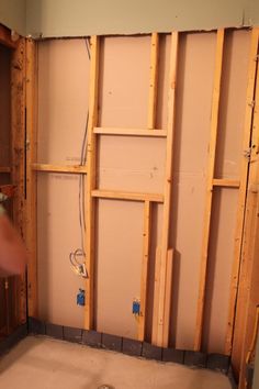 a man is working on the wall in his bathroom that's being built into the floor