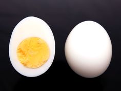 an egg is cut in half and placed next to another one on a black surface