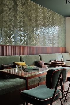 a long table with two chairs next to it in front of a wall covered by bamboo blinds