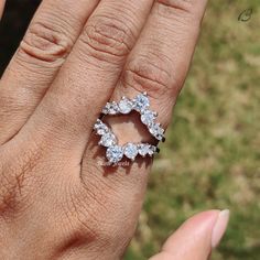 a woman's hand with a diamond ring on top of her finger and the other hand holding it