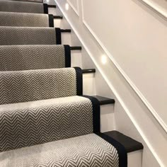 the stairs are lined with black and white carpet