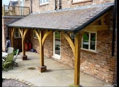 an outside patio area with tables, chairs and a covered dining table in front of a brick building