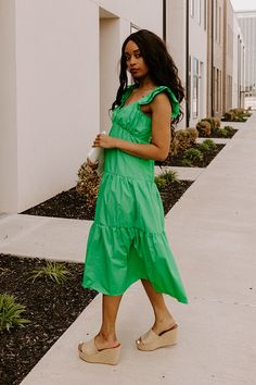 - This sweet dress is perfect for a sunny day! - Lightweight, green hued material with a lined bust - A scoop neckline - A bust with gathered detail - Flutter sleeves with elastic shoulders - A smocked upper back - A relaxed silhouette that ends in a straight midi length hemline Chic Green Midi Dress With Ruffle Hem, Summer Green Midi Dress With Ruffle Hem, Green Ruffled Sundress Midi Dress, Casual Kelly Green Summer Dress, Green Ruffled Straps Vacation Dress, Green Vacation Dress With Ruffled Straps, Green Spring Midi Dress With Ruffled Straps, Green Midi Dress With Ruffled Straps For Spring, Green Spring Dresses With Ruffled Straps