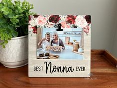 a wooden frame with the words best mom ever and an image of two people sitting at a table