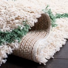 a close up of a rug on the floor with it's end rolled down