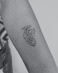 a man's arm with a heart tattoo on it