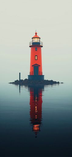 a red light house sitting on top of a body of water