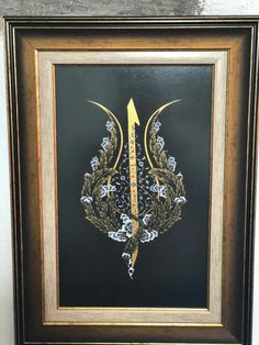 a painting hanging on the wall next to a wooden framed frame with an arrow in it