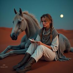 a woman is sitting on the ground next to a horse and reading a book at night