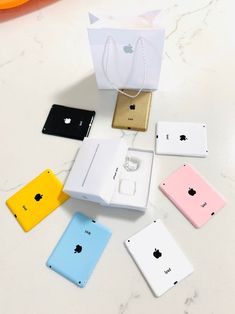 an assortment of apple products are displayed on a white table with orange and blue bags