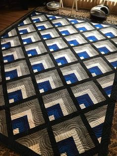 a blue and white quilt on top of a table next to a pair of shoes