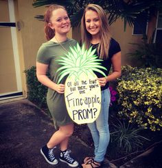 two girls are holding a sign that says pineapple from? and palm tree with leaves on it