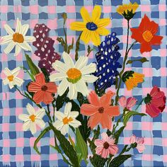 a vase filled with colorful flowers on top of a blue and pink checkered table cloth