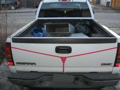 the back end of a white truck parked in a parking lot