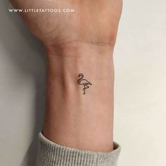 a small black and white flamingo tattoo on the left wrist by little tatoos