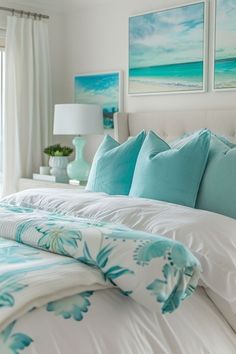 a bed with blue and white comforters in a bedroom next to a window overlooking the ocean