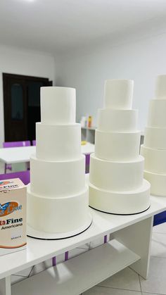 there are many white cakes sitting on the table with one box next to each other