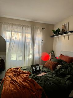 a bed room with a neatly made bed and a red light on the window sill