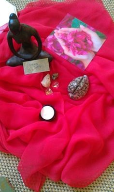 a table topped with a red cloth covered in items