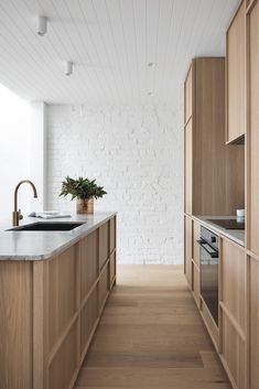 a kitchen with white brick walls and wooden cabinets