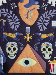 an image of a quilt with skulls and other things on the front, including a clock