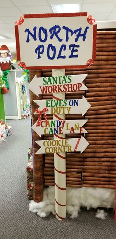 a pole that has signs on it in the middle of a room with christmas decorations